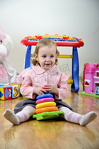 立方体的兔子摄影照片_“小女孩在房间里玩玩具，玩彩色金字塔”
