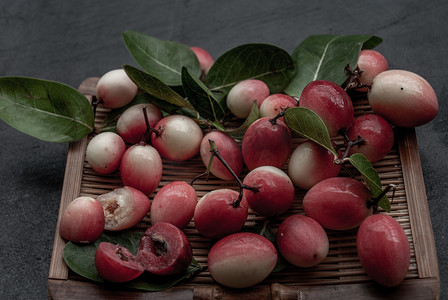 酸味摄影照片_Bengal-Currants、Carandas-plum 或 Karonda 水果 (Carissa carandas L.) 柳条上的酸味水果。