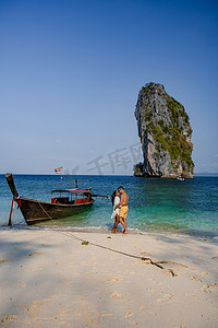 宝船摄影照片_泰国 Koh Poda 岛，一对中年亚洲女人和欧洲男人在海滩上，泰国 Koh Poda，美丽的热带海滩 Koh Poda 或泰国甲米省的 Poda 岛。