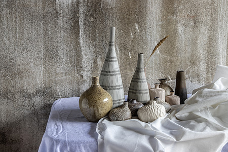 白色桌子上手工制作的各种不同的陶瓷花瓶。
