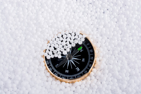 泡沫球摄影照片_白色聚苯乙烯泡沫球上的指南针