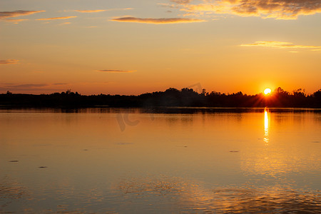 平静的湖面上倒映着五彩缤纷的夕阳。