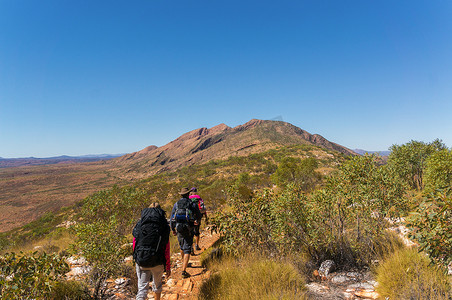 一群徒步旅行者正在前往澳大利亚西麦克唐纳国家公园爱丽丝泉外的桑德山顶