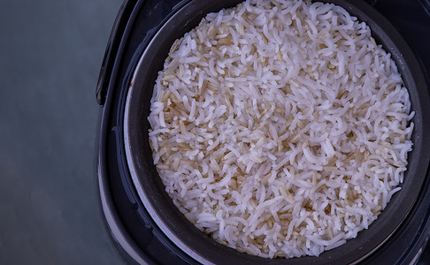 电饭锅海报摄影照片_茉莉香米与粗糙米混合在电饭锅中蒸煮。