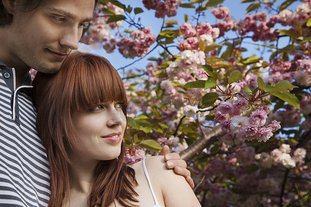 开花的树下的年轻夫妇