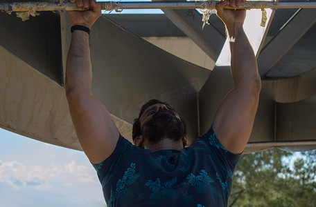 公园锻炼身体摄影照片_身穿短袖 T 恤锻炼的强壮男子