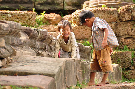 柬埔寨吴哥 — 2013 年 8 月 28 日：石篱上快乐的民族孩子，亚洲小男孩在吴哥窟古庙的石篱上共度时光。