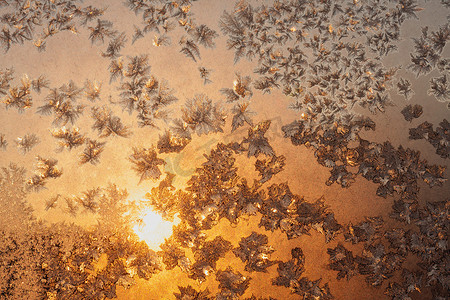 太阳和雪花摄影照片_结冰的窗户上的雪花和冰