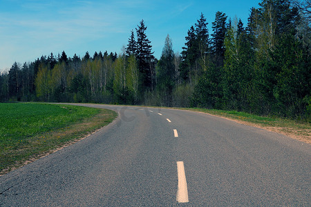 美丽的风景道路旁边是一片绿色的森林。