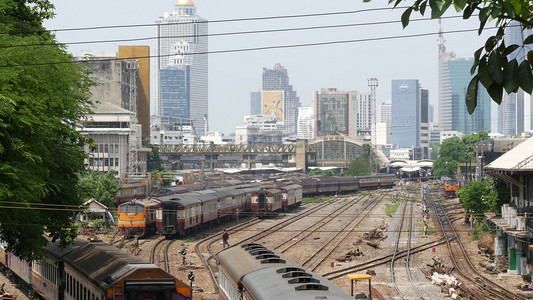 华为自拍杆摄影照片_泰国曼谷 — 2019年7月11日：以城市景观和摩天大楼为背景的火车站景观。