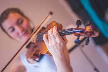 练习古典音乐和小提琴概念：小女孩愉快地拉小提琴