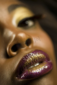 紫色和金色摄影照片_涂着紫色和金色口红的年轻女子