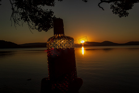 澳大利亚新南威尔士州克劳迪湾国家公园沃森泰勒湖日落前装满朗姆酒的漂亮朗姆酒瓶
