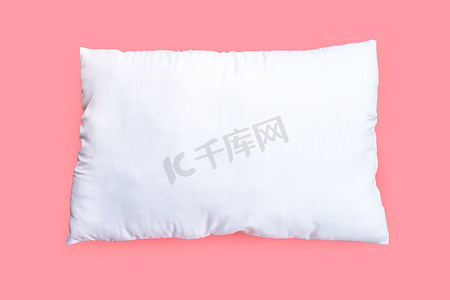 白色发光摄影照片_粉红色背景上的白色枕头。