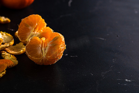切橙子摄影照片_在黑色背景上切橙子。