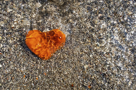 沙滩上的橙色心形石头