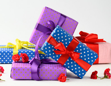 盒子用带圆点的节日纸包装，并用丝带绑在背景上，生日礼物