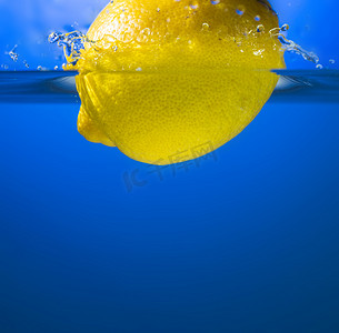 黄色柠檬水花溅起摄影照片_在水飞溅的黄色柠檬