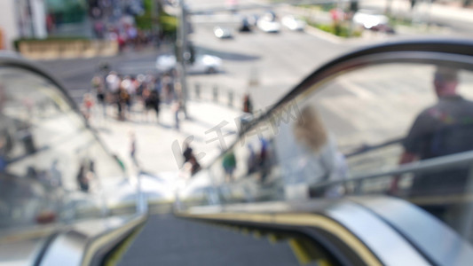 通过自动扶梯的透视图，在美国拉斯维加斯大道的道路交叉口人行横道上散焦的无法辨认的人群。