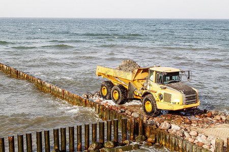 在海边建造防波堤期间的重型卡车