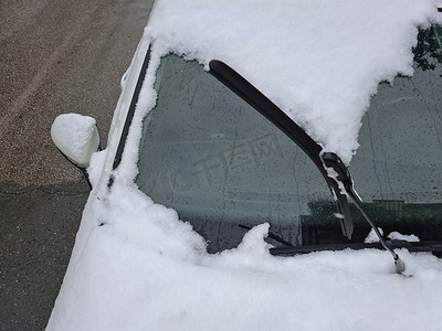 在一辆被雪覆盖的汽车前抬起雨刷器。