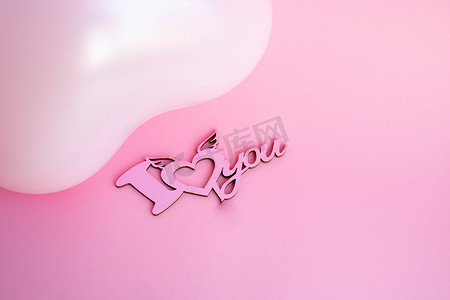 粉色背景上心形的粉色气球，上面写着我爱你。