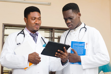 两位常务医生在办公室共享一台数字平板电脑。