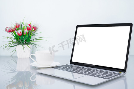 笔记本电脑模型和带花的咖啡杯
