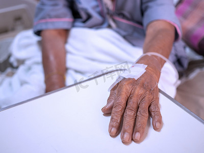 在医院里，生理盐水滴在老妇人的手上。