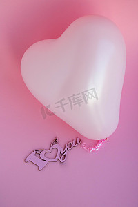 粉色婚礼背景设计摄影照片_粉色背景上心形的粉色气球，上面写着我爱你。