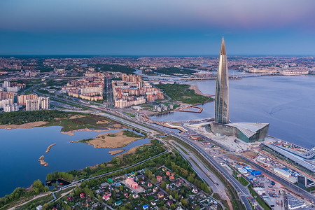 俄罗斯，圣彼得堡，2021 年 5 月 16 日：粉红色夕阳下欧洲最高摩天大楼拉赫塔中心的无人机视角，俄罗斯天然气工业股份公司总部，背景为俄罗斯天然气工业股份公司竞技场