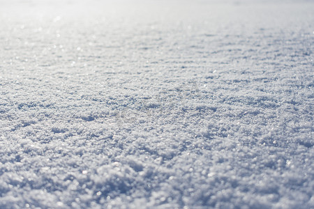 多雪的表面，冬天在阳光下覆盖着一层致密的雪的表面