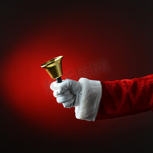 浅红底板摄影照片_圣诞老人在浅红色到深红色背景上摇铃