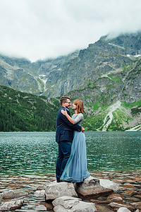 年轻夫妇在群山环抱的湖边散步