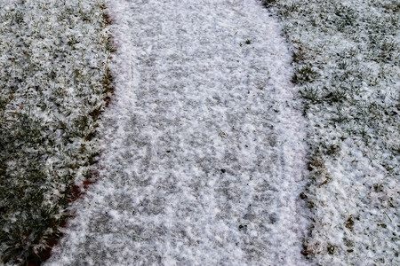 冬天，一条古老的鹅卵石路上的白雪表面。