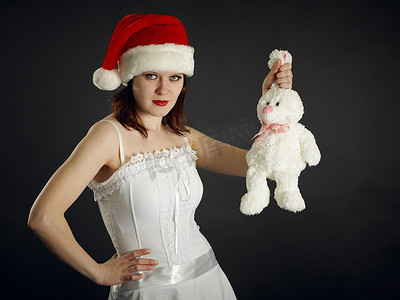 圣诞帽的年轻女人拿着一只兔子