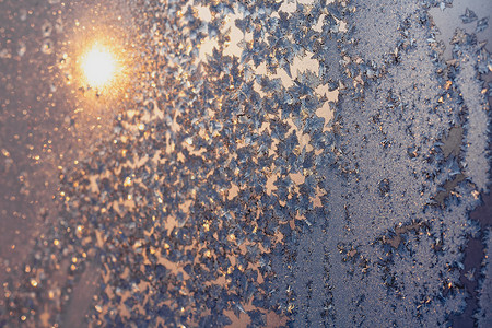 太阳和雪花摄影照片_结冰的窗户上的雪花和冰