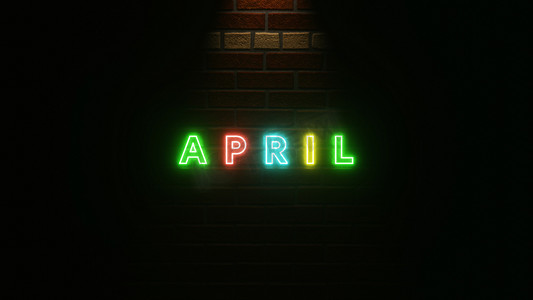 四月文本霓虹灯在砖墙纹理上五颜六色。 