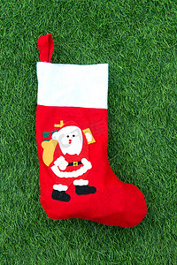 挂圣诞袜摄影照片_绿草地上的圣诞袜