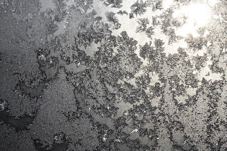 太阳和雪花摄影照片_结冰的窗户上的雪花和冰