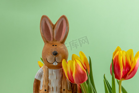 复活节兔子和带黄色红色郁金香的花束