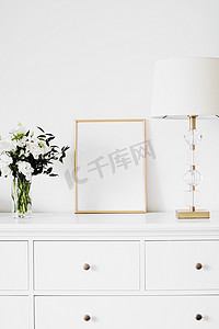 白色家具上的金色垂直框架和鲜花花束、豪华家居装饰和模型创作设计