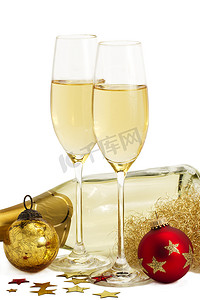 “香槟酒瓶前放着两杯天使头发、红色和金色圣诞球的香槟”