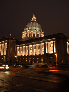 旧金山市政厅在夜间照亮。雨后反射