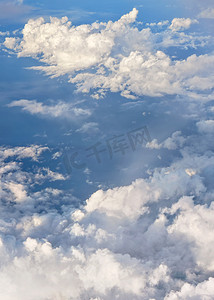 蓬松的天空云被午后的阳光照亮，从飞过的商用飞机上看
