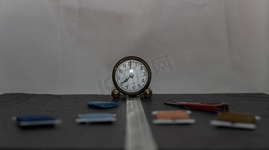 时钟被针、线和缝纫卷尺等缝纫用具包围。