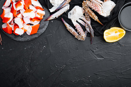蟹棒海鲜半成品鱼肉和蓝梭子蟹，在石板上，黑色背景，顶视图平躺，有复制空间和文本空间