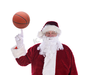 圣诞老人用他的食指指着一个在尖端平衡的篮球足球，与白色隔离