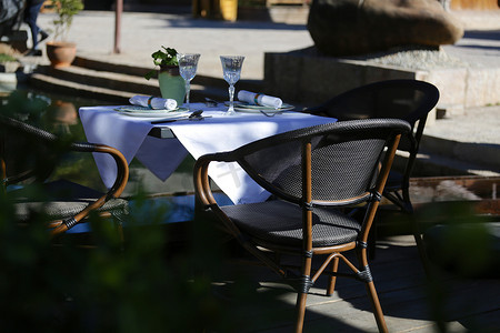 带桌椅的露台餐厅环境被绿色植物包围。