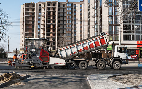 KYIV, UKRAINE - September 10, 2020：工业沥青摊铺机在街上的道路施工现场铺设新鲜沥青。